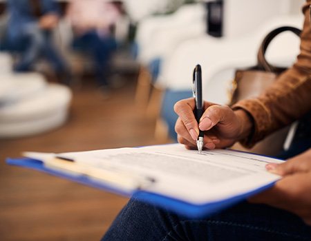 Woman filling out dental insurance form in lobby