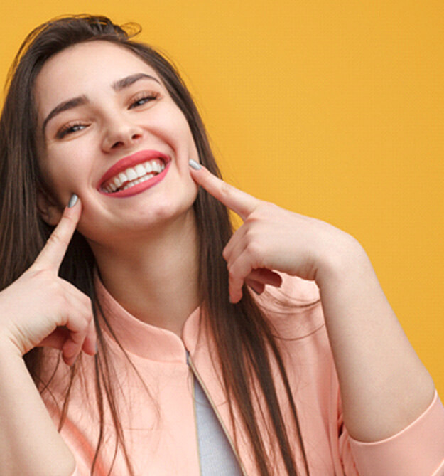 smiling woman pointing to her teeth