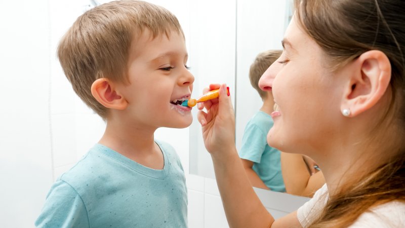 Mother brushing son’s teeth